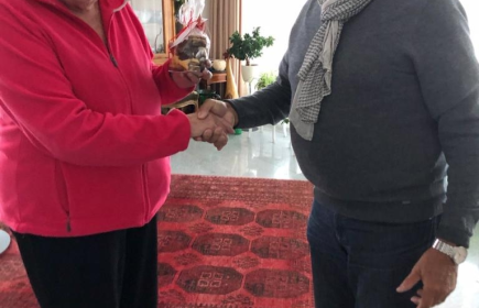 Ein Mitglied des RC Arosa übergibt die selbst gebackenen Guetzli einer Seniorin.